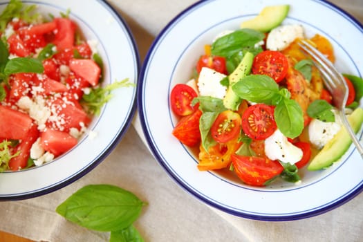 A watermelon feta salad next to a caprese from overhead