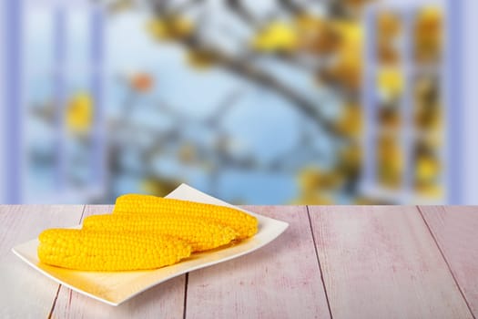 Ripe fresh corn fruits on rustic wooden table in front of natural blurred background. For your food and product display montage. Concept food.