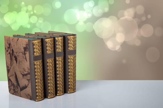 Old books on table with bright bokeh background. Space for your product display montage. Concept education.