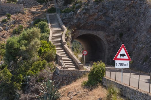 Observation platform "Mirador de Ricardo Roca"" near Estellencs with a small chapel on the west coast of Majorca and road sign Attention Wildlife - Boar - Danger from wildlife"