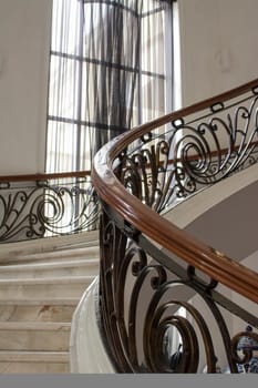 Marble stairs with handrails decorated in wood and steel