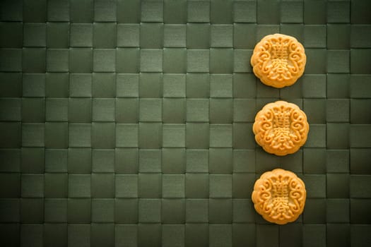 Traditional pastry mooncakes is eaten during the Mid-Autumn Festival. Flatlay table top view low light with copy space. The Chinese character represent "lotus paste""."