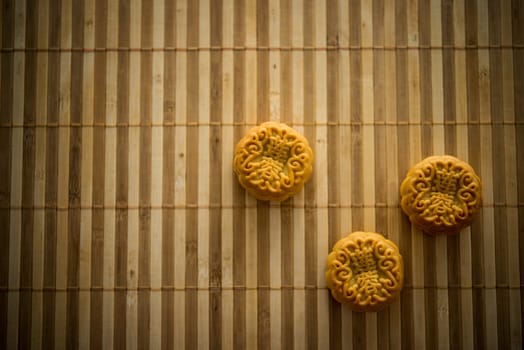 Traditional pastry mooncakes is eaten during the Mid-Autumn Festival. Flatlay table top view dark light with copy space. The Chinese character represent "lotus paste""."