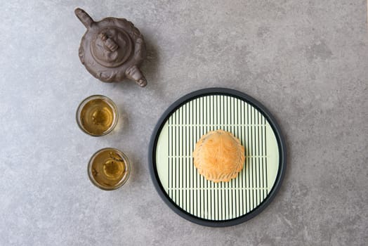 Traditional mooncakes is offered to friends or family during Mid-Autumn Festival. Flatlay on table top down view grey background with copy space. The Chinese character represent "lotus paste""."