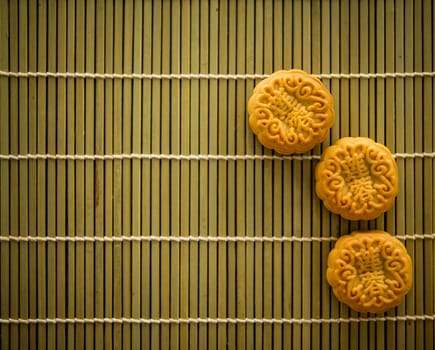 Traditional pastry mooncakes is offered to friends or family during Mid-Autumn Festival. Flatlay on table, top down view low light with copy space. The Chinese character represent "lotus paste"" ."