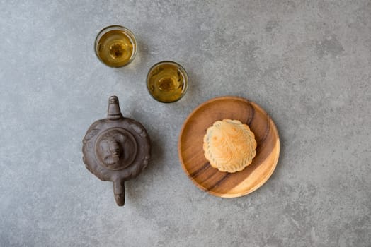 Traditional baked mooncakes is offered to friends or family during Mid-Autumn Festival. Flatlay on table top down view grey background with copy space. The Chinese character represent "lotus paste""."