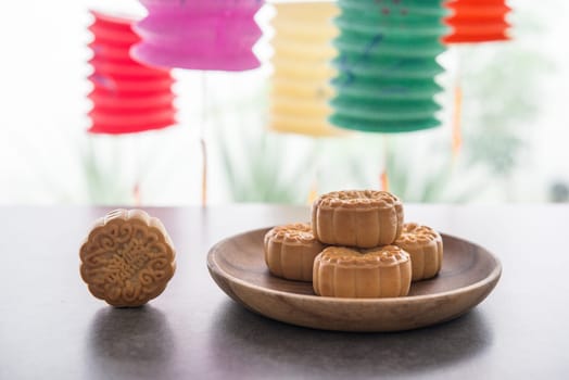 Moon cakes is traditionally baked pastry to eaten during Mid-Autumn Festival. Lanterns at background. The Chinese character represent "lotus paste""."