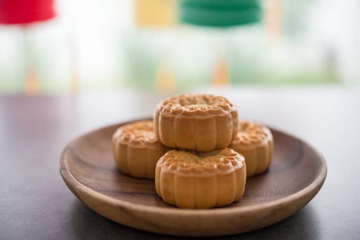 Mooncakes is traditionally baked pastry to eaten during Mid-Autumn Festival. Lanterns at background. The Chinese character represent "lotus paste""."