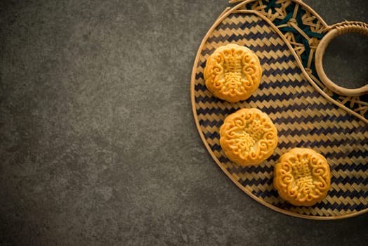 Traditional pastry mooncakes is offered to friends or family during Mid-Autumn Festival. Flatlay table top view dark light with copy space. The Chinese character represent "lotus paste""."