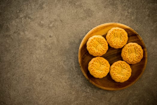Moon cakes is traditional pastry eaten during the Mid-Autumn Festival. Flatlay on table, top down view with copy space. The Chinese character represent "lotus paste""."