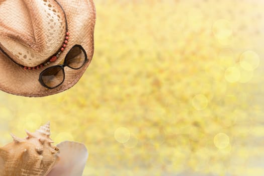 Summer fashion, straw hat, sun glasses and sea shell on illustrated yellow sandy beach. Travel and vacations concept. Holiday season.