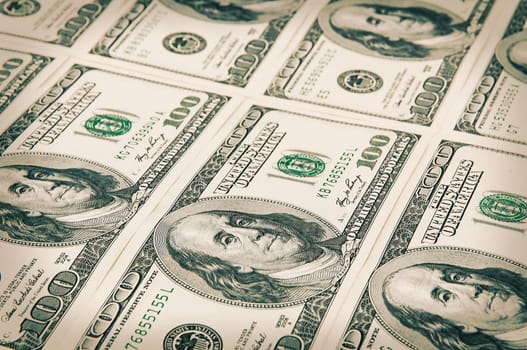 Denominations of one hundred dollars are arranged in a row. Processing under the antiquity. View at an angle. Isolated.