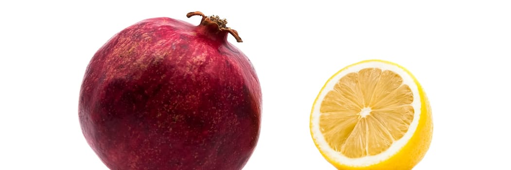 Ripe pomegranate and lemon on a white background. Close-up.