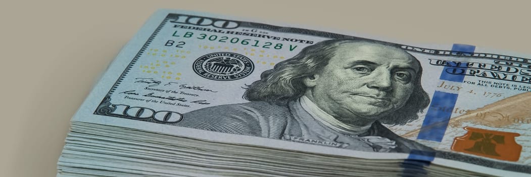 Part of the bundle with a bill shift of one hundred dollars. On a gray background. View at an angle.