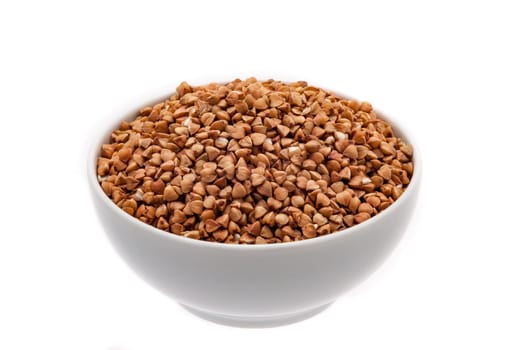 Buckwheat groats in a white cup close-up on a white background.