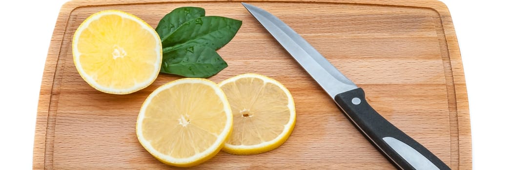 On the cutting board are a few slices of fresh lemon and a knife.