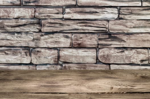 The background is a wall of large brown bricks and wooden boards.