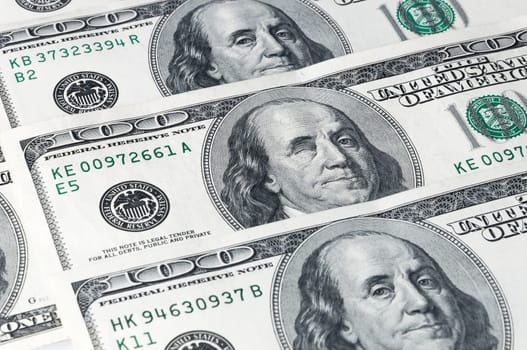 Denominations of one hundred dollars, located on a diagonal. Franklin winks.