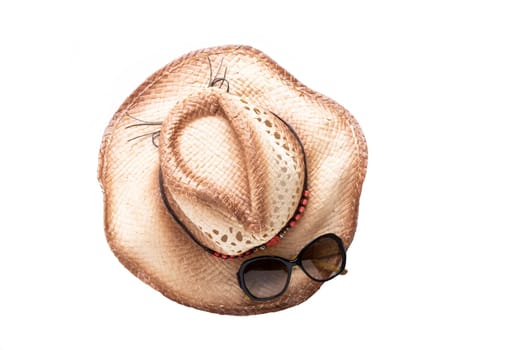 Closeup straw hat and sun glasses isolated on white background. Travel and vacations concept. Holiday season.