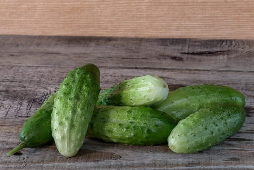 Fresh green cucumbers on a wooden background