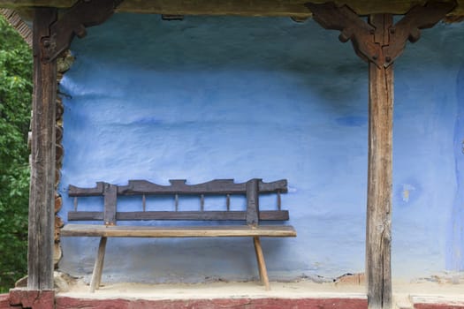 Old Wood Bench with Blue Log House