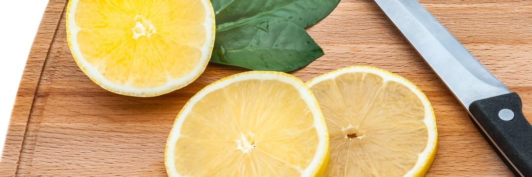 There are a few slices of lemon and a knife on the board.