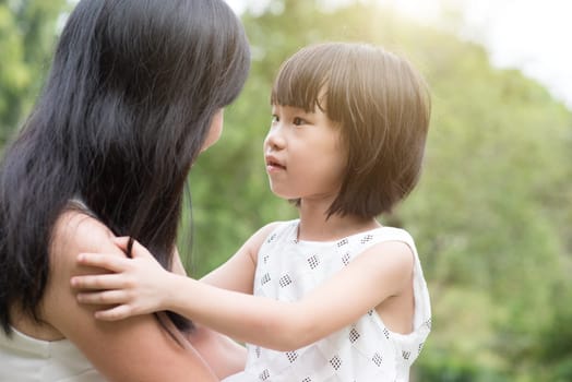 Asian family outdoors portrait. Mother and daughter enjoying at garden park.