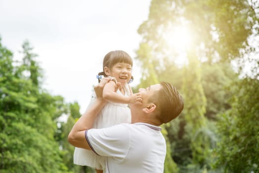 Asian family outdoors portrait. Father and daughter bonding at garden park.