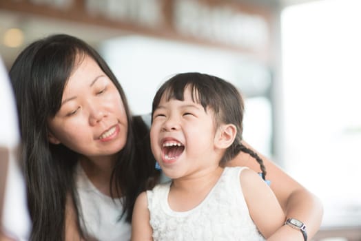Candid shoot of people in cafeteria. Little girl with various face expression. Asian family outdoor lifestyle with natural light.