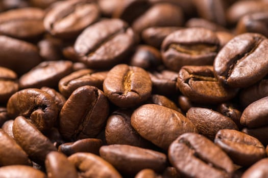 Roasted organic whole dark coffee beans, close up