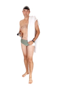 A tall handsome man in a green swimsuit standing from the front.with his towel and swim google and cap isolated on white background.