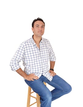 A portrait of a young mans sitting in a checkered shirt and jeans on a.chair, looking into the camera, isolated for white background.