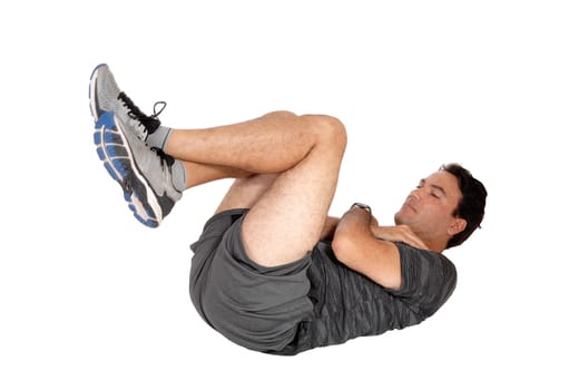 A young tall man lying on the floor doing his exercise in sit-ups in.shorts and sneakers, isolated for white background.