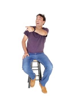 A happy tall man sitting on a chair, laughing and pointing with his finger.away, isolated for white background.