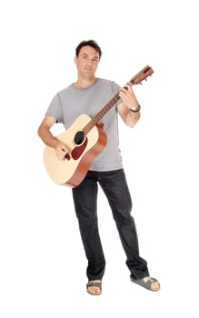 A young handsome man standing with his guitar and playing a song.in jeans and t-shirt, isolated for white background.