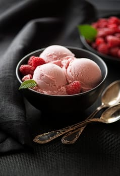 Homemade organic Raspberry ice cream scoops in black bowl