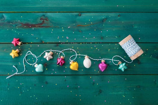 Cheerful christmas garland made from baubles on wooden background
