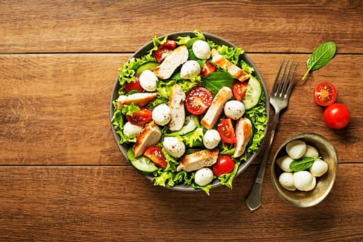 Fresh green salad with chicken breast tomato and mozzarella cheese