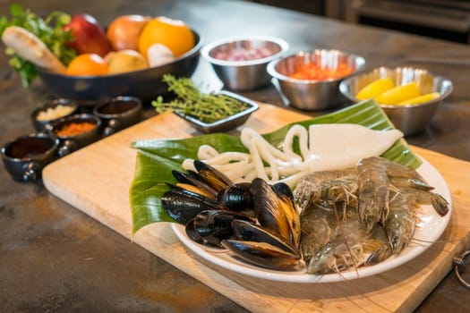 Raw seafood on plate with fruits and vegetables, healthy food, prawn, clam squid.