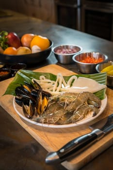 Raw seafood on plate with fruits and vegetables, healthy food, prawn, clam squid.