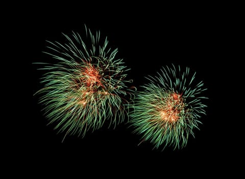 Green and red exploded fireworks display, isolated on black background