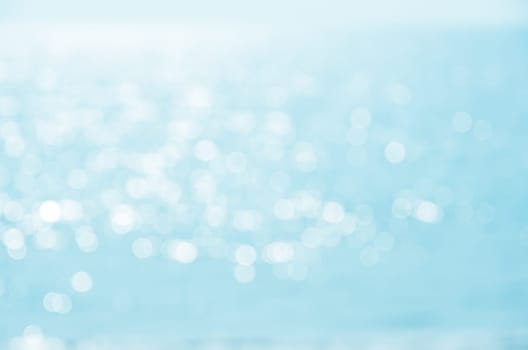 Blur blue sea water bokeh abstract background with sunshine