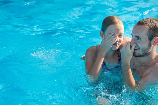 Brother and sister in a swimming pool on a summer day