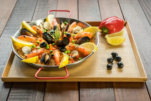 Paella with seafood vegetables and saffron served in the traditional pan.