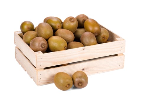 Wooden box filled with many ripe and fresh kiwi fruits and two whole fruits in front of it isolated on white background