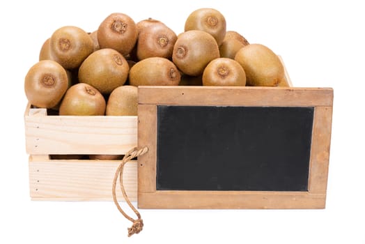 Wooden box filled with many ripe kiwi fruits and a old blank slate blackboard isolated on white background