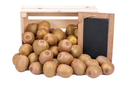 Wooden box filled with many ripe kiwi fruits and a old blank slate blackboard isolated on white background