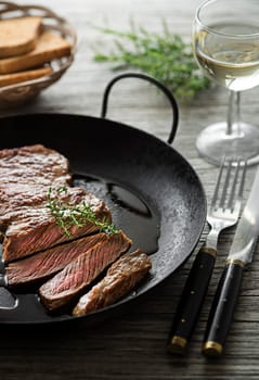 Grilled beef steaks with spices on wooden table