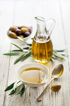 Bottle of Extra virgin healthy Olive oil with fresh olives on wooden background