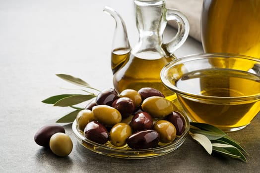 Bottle of Extra virgin healthy Olive oil with fresh olives close up